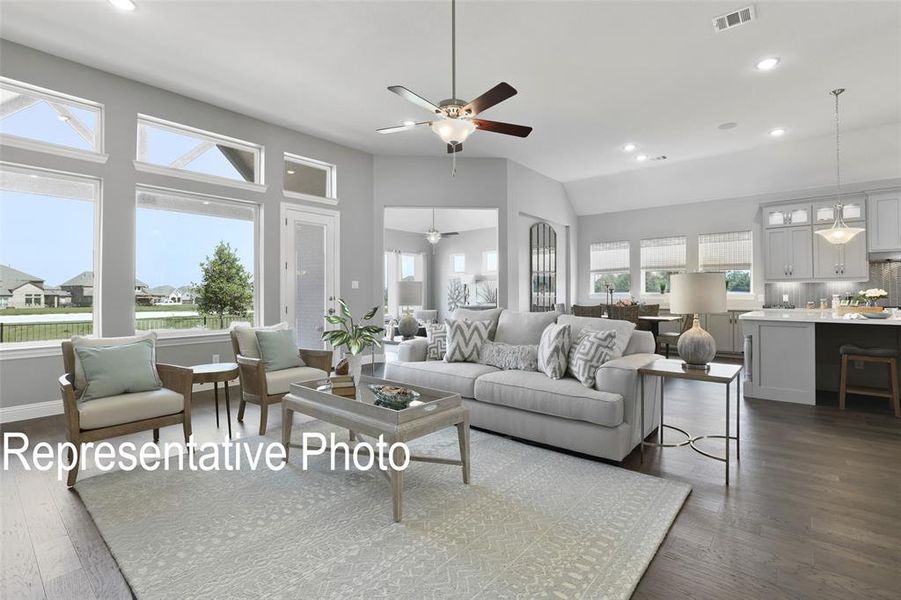 Living room with high vaulted ceiling, ceiling fan, and dark wood-type flooring