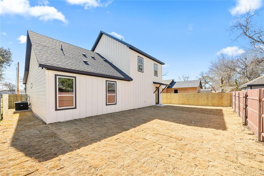 Rear view of house with a shingled roof, a fenced backyard, and a patio Rear view of house with a shingled roof, a fenced backyard, and a patio