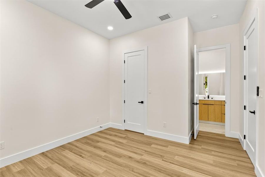 Spacious room featuring wood-finish flooring, recessed lighting, and a ceiling fan