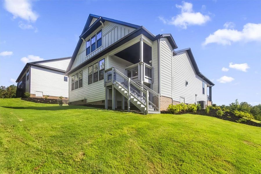 A spacious grassy slope leads up to the rear eleva
