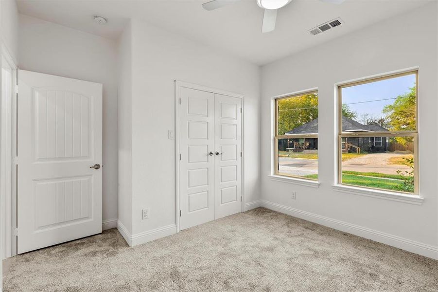 Unfurnished bedroom with light carpet, a closet, and ceiling fan