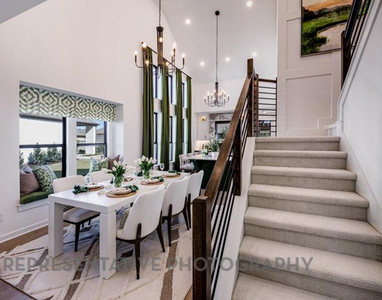 Stairway with an inviting chandelier, recessed lighting, baseboards, and a towering ceiling Stairway with an inviting chandelier, recessed lighting, baseboards, and a towering ceiling