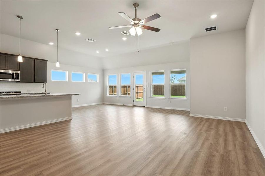 Unfurnished living room with recessed lighting, plenty of natural light, light wood finished floors, and a ceiling fan