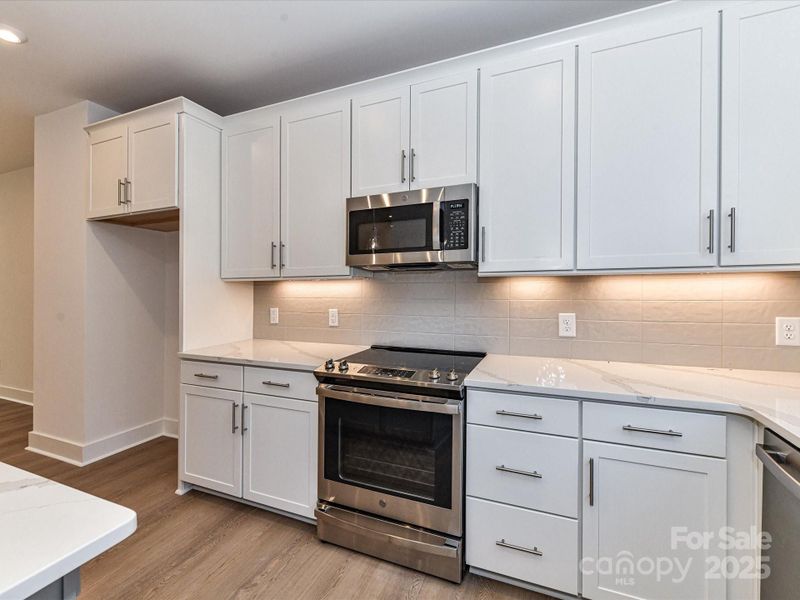 Stainless Steel GE Appliance Package and Striking Veining on Countertops.