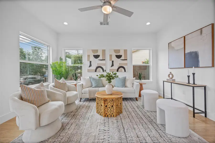 A welcoming living area boasts an open floor plan with hardwood flooring and ample natural light from multiple windows. A welcoming living area boasts an open floor plan with hardwood flooring and ample natural light from multiple windows.