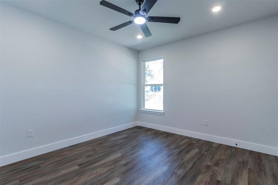 Unfurnished room with dark hardwood / wood-style flooring and ceiling fan