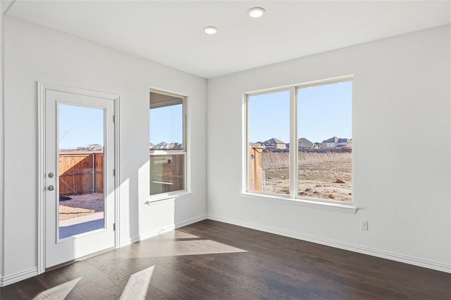 Bright room featuring dark wood-finish flooring, white walls, and recessed lighting