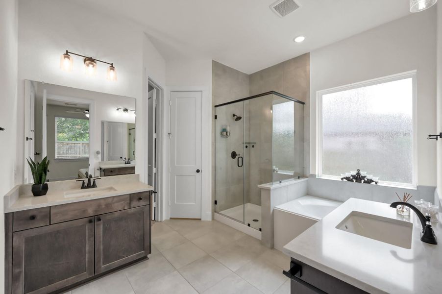 Luxurious primary bathroom featuring a spacious walk-in shower, relaxing soaking tub, double sinks, and elegant finishes designed for comfort and style.