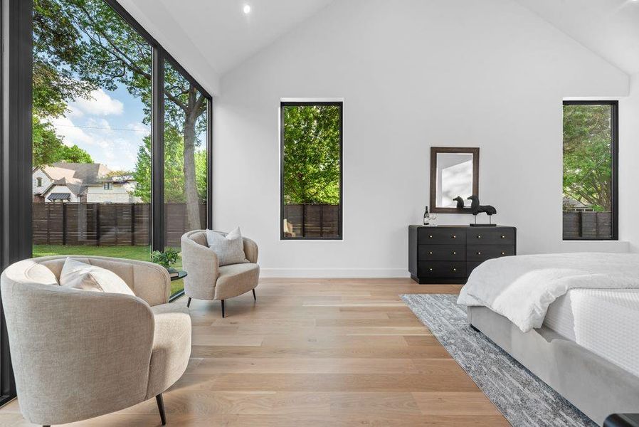 Clean lines, smooth finished walls, and white oak flooring create a calm, refined atmosphere throughout the primary suite.