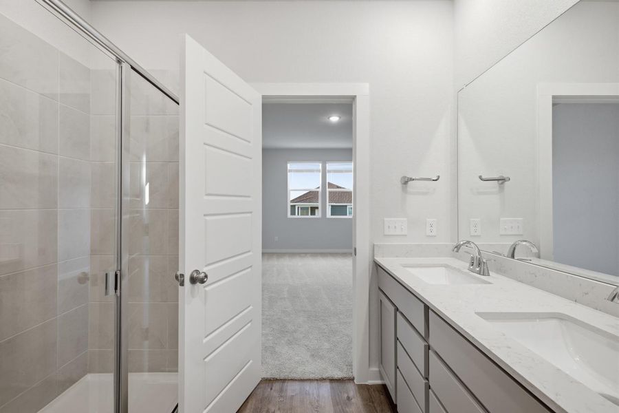 Clean lines define this bright bathroom with a dual vanity and glass-enclosed shower.