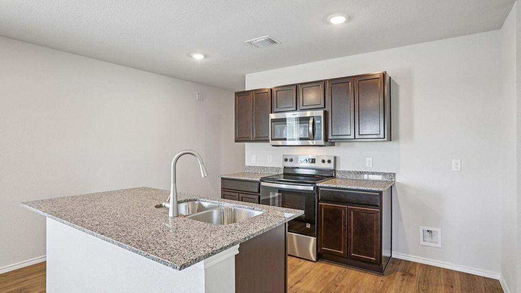 Culinary dreams come alive in this kitchen, featuring an island and modern stainless steel appliances.