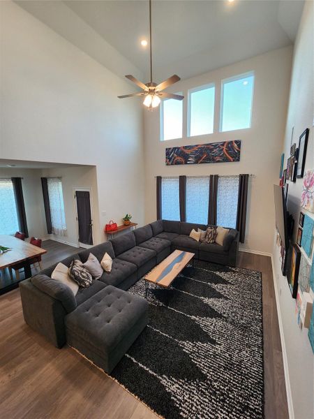 An airy living area features high ceilings and tall windows, creating a bright and inviting atmosphere.