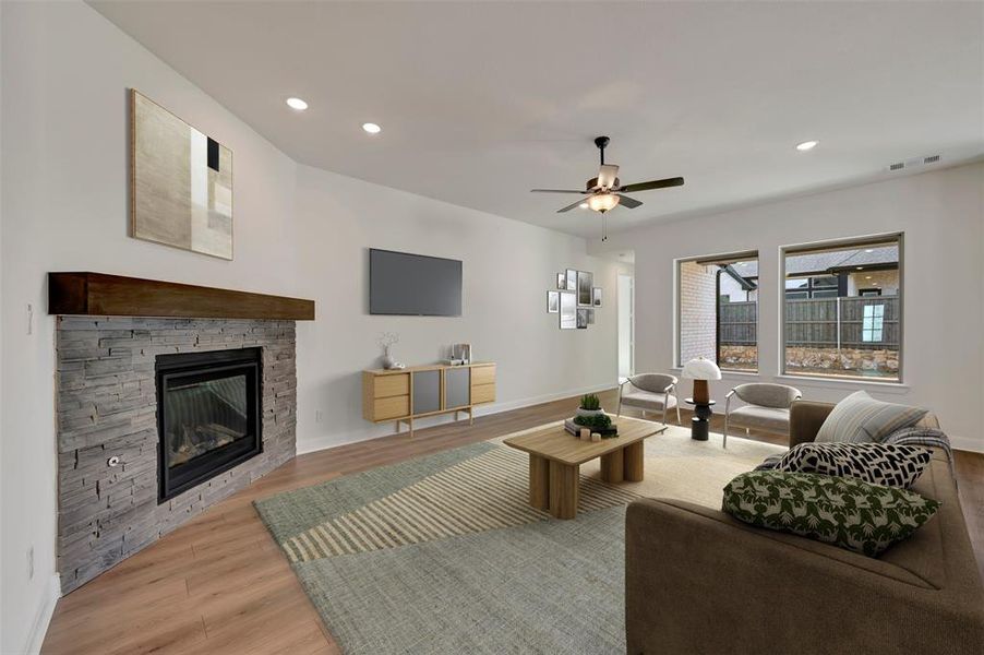 Living area with light wood finished floors, a fireplace, recessed lighting, and ceiling fan
