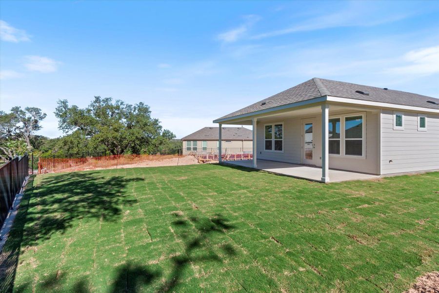 Back of house with a fenced backyard, a patio, and roof with shingles