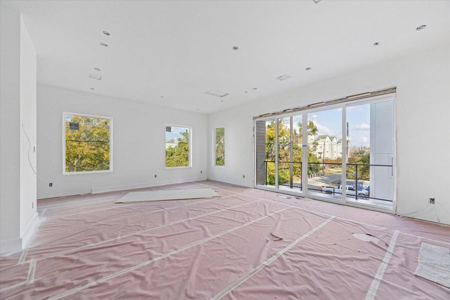 View of the living room, dining room and sliding glass doors leading to the balcony as of December 12, 2025.