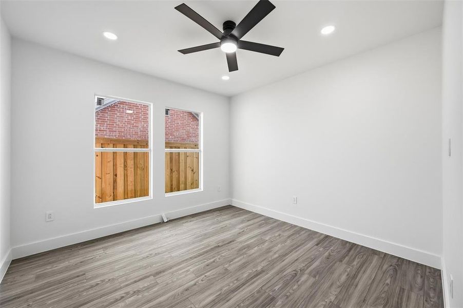 Empty room with wood finished floors, a ceiling fan, and recessed lighting Empty room with wood finished floors, a ceiling fan, and recessed lighting
