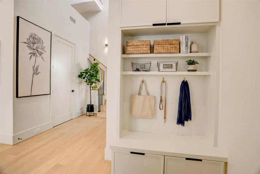 As you enter from the garage, a built-out mud cabinet allows you to drop your things as you enter the door.