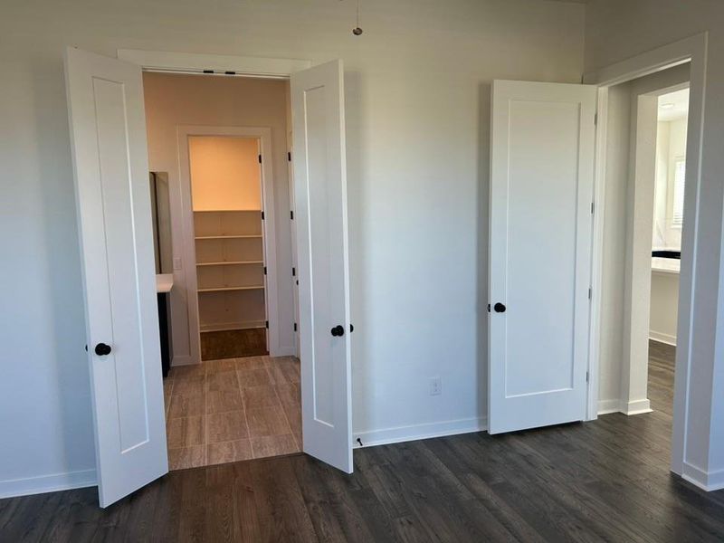 Hallway with dark wood-style floors and baseboards Hallway with dark wood-style floors and baseboards