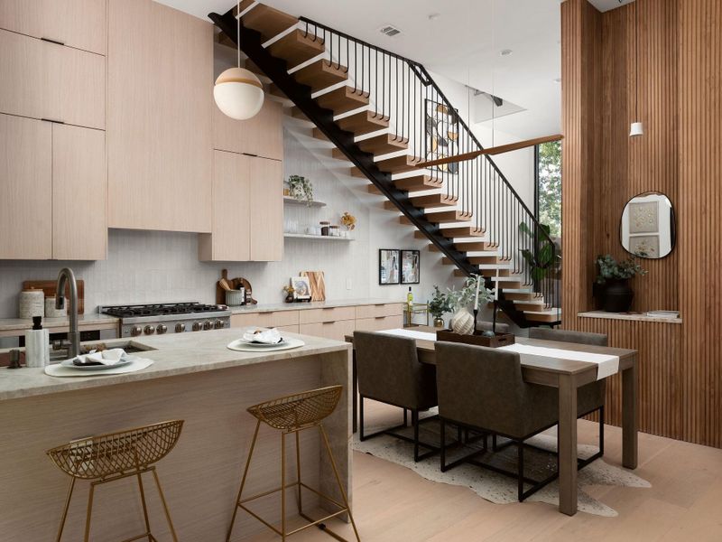 Modern cabinetry and an architectural staircase define this striking open-concept kitchen and dining area.