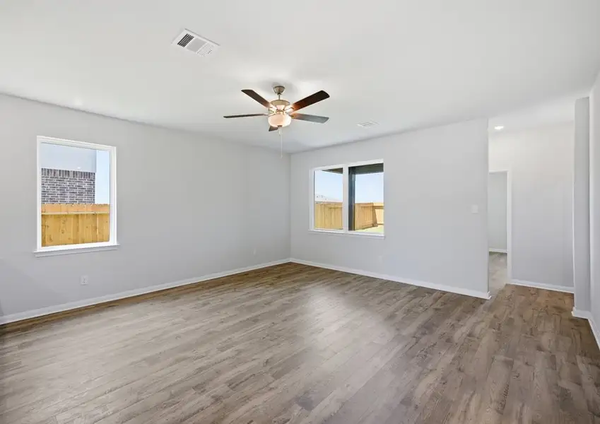 Family room with ceiling fan and windows in Montgomery floor plan