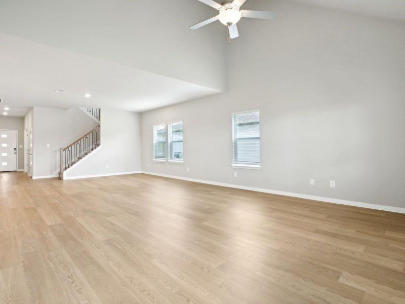 Unfurnished living room featuring stairway, ceiling fan, baseboards, light wood finished floors, and recessed lighting Unfurnished living room featuring stairway, ceiling fan, baseboards, light wood finished floors, and recessed lighting