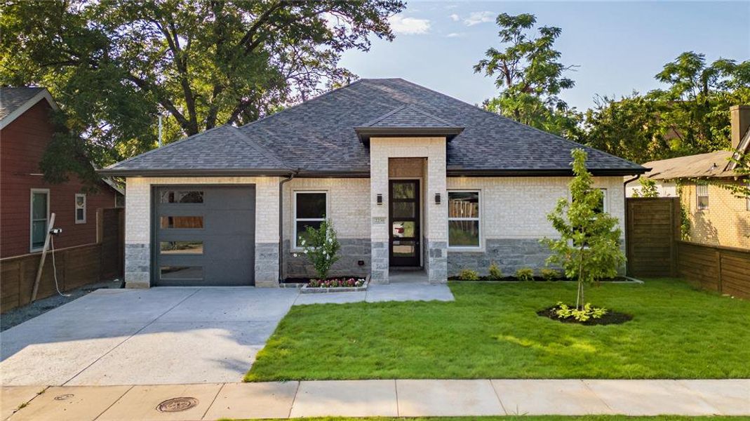 View of front facade featuring a front lawn and a garage