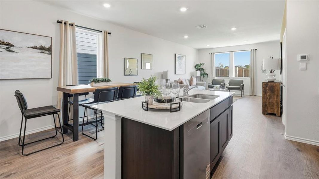 Kitchen featuring dishwasher, light stone countertops, light wood-style floors, open floor plan, and recessed lighting