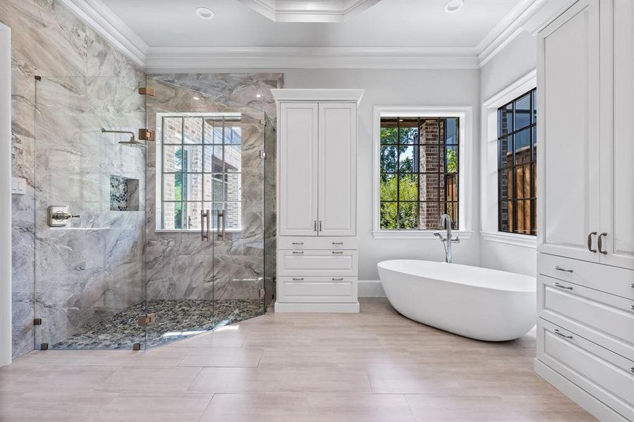 Bathroom with tile patterned flooring, independent shower and bath, and ornamental molding