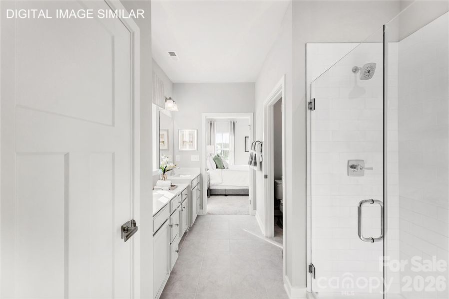 Spa-like primary bath with dual vanities, private water closet, linen storage, and walk-in shower featuring dual shower heads and built-in bench. Spa-like primary bath with dual vanities, private water closet, linen storage, and walk-in shower featuring dual shower heads and built-in bench.