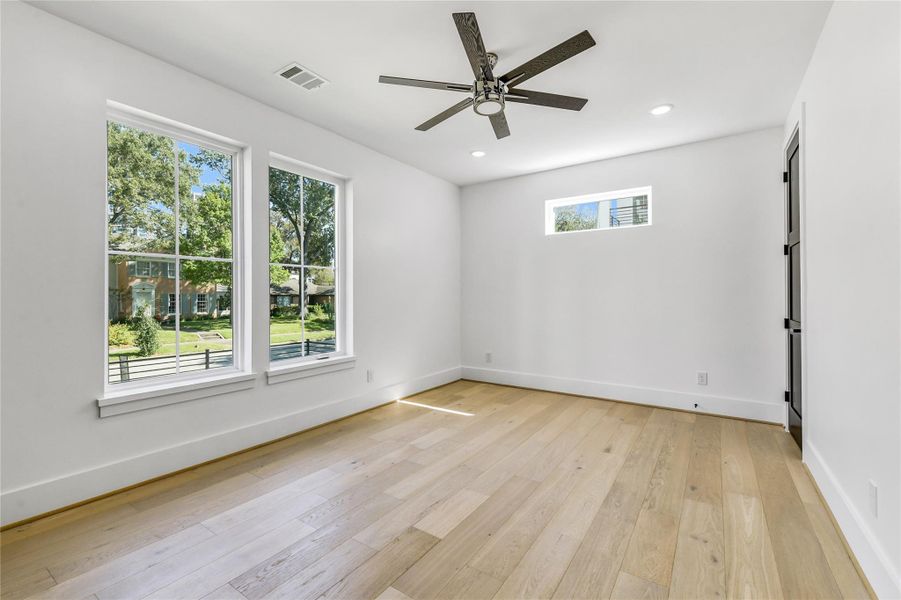 This view showcases the architectural symmetry and light-filled design of the space. The clerestory window adds privacy while maintaining brightness, and the crisp white walls serve as the perfect canvas for personal style. A modern ceiling fan with integrated lighting and recessed LED fixtures ensure comfort and functionality year-round. This view showcases the architectural symmetry and light-filled design of the space. The clerestory window adds privacy while maintaining brightness, and the crisp white walls serve as the perfect canvas for personal style. A modern ceiling fan with integrated lighting and recessed LED fixtures ensure comfort and functionality year-round.