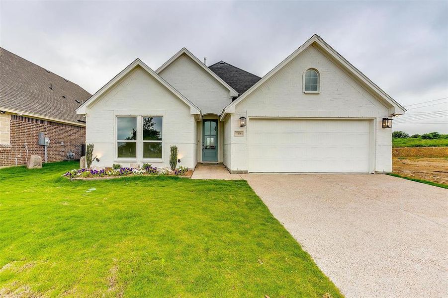 View of front facade with a front lawn and a garage