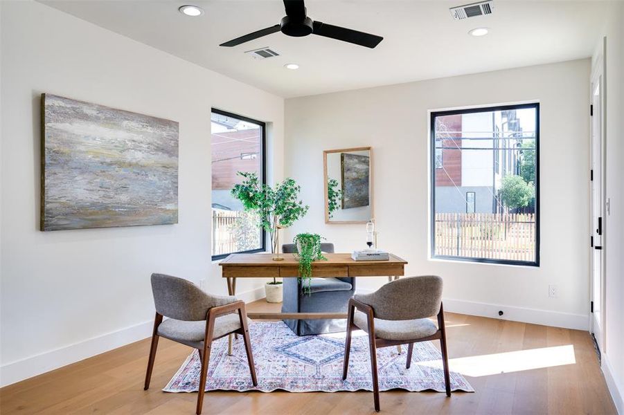 Office space featuring a healthy amount of sunlight, wood-type flooring, and ceiling fan