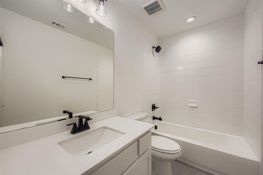 Bathroom featuring vanity, shower / bath combination, and recessed lighting