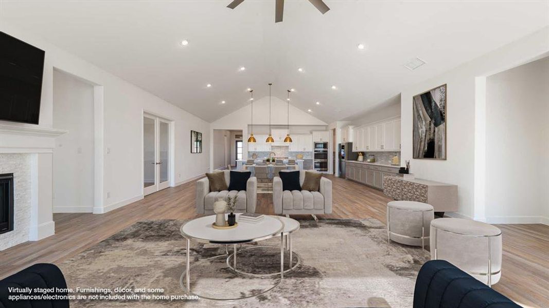 Living room featuring vaulted ceiling, light hardwood / wood-style flooring, and ceiling fan