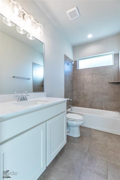 Bathroom featuring vanity, shower / bathtub combination, and lighting
