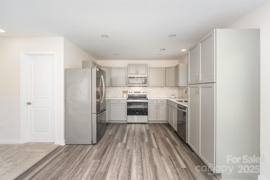 Modern style meets everyday function: stainless steel appliances, quartz countertops, and a classic subway tile backsplash. Modern style meets everyday function: stainless steel appliances, quartz countertops, and a classic subway tile backsplash.