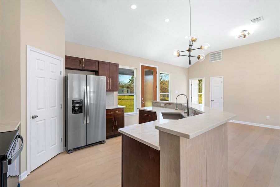 A wide-angle captures the fullkitchen layout, includinggenerous storage, elegantfinishes, and a seamlessconnection to living anddining areas.