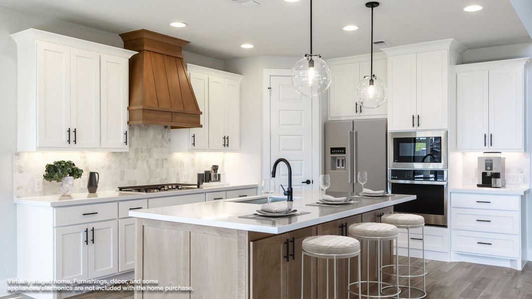 Kitchen featuring backsplash, a breakfast bar, stainless steel appliances, a center island with sink, and recessed lighting