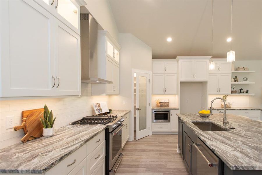 Kitchen with custom cabinets, stainless steel appliances, and sink