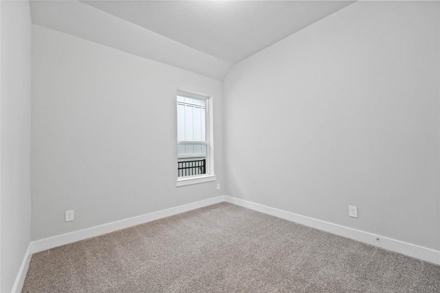 This inviting secondary bedroom combines comfort and modern elegance, featuring high sloped ceiling, a soft neutral color palette, large window with an abundant of natural light streaming through, and an ample sized closet.