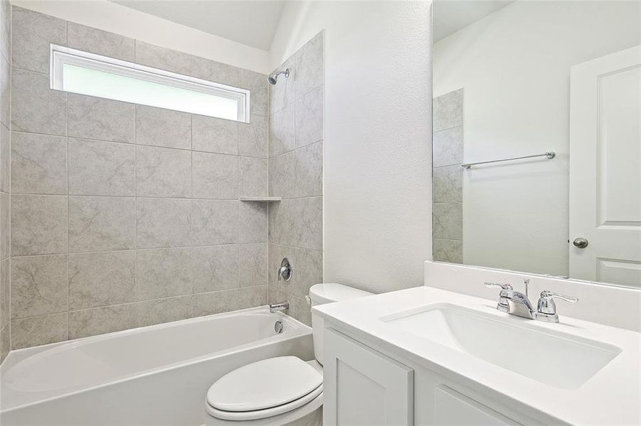 Full bathroom featuring toilet, tiled shower / bath, and vanity