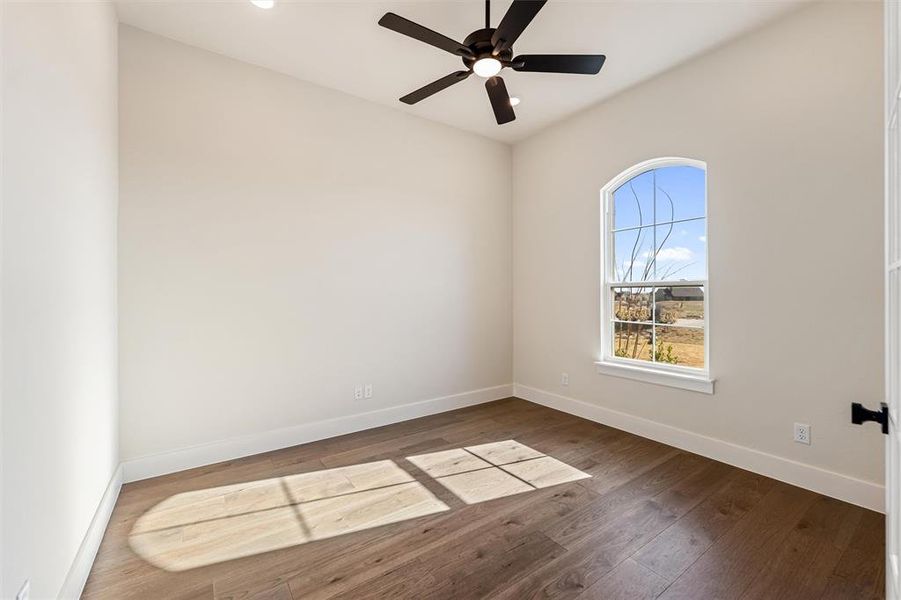 Spare room featuring dark wood finished floors and ceiling fan