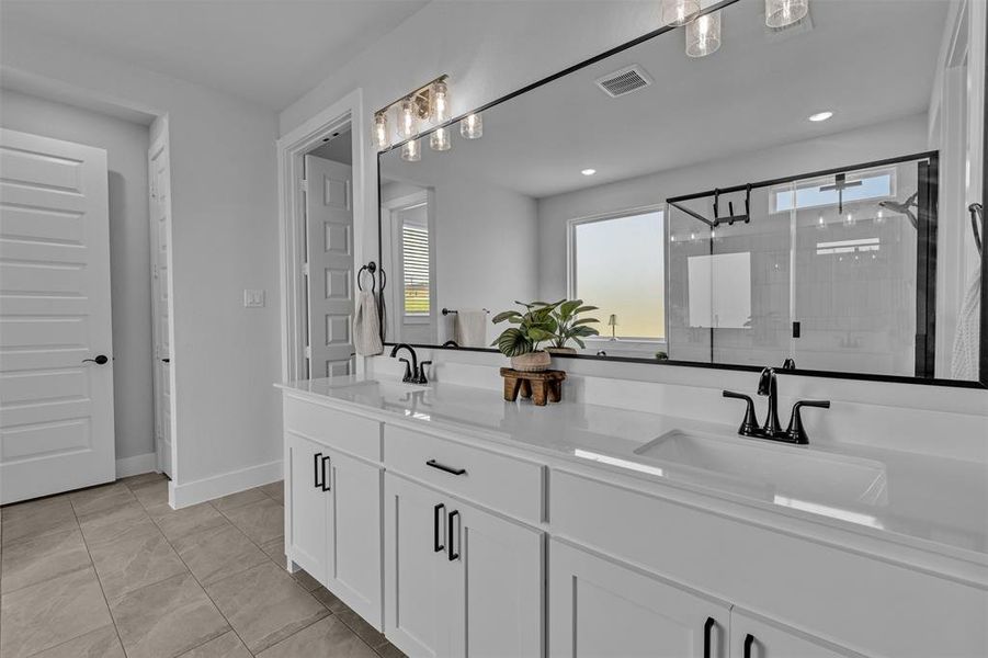 Double vanity with white cabinetry, matte black hardware, and integrated sinks