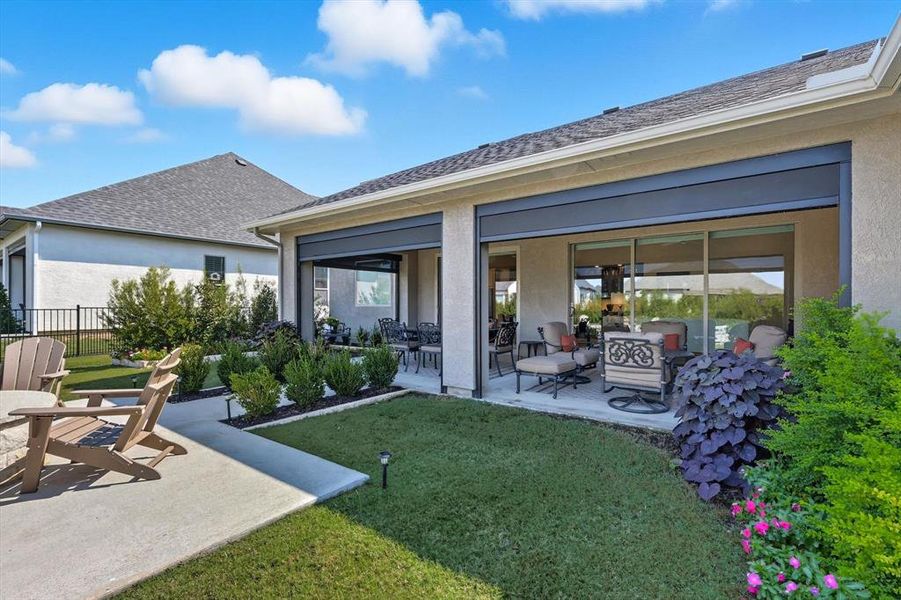 Rear view of house featuring stucco siding, a patio area, and an outdoor living space