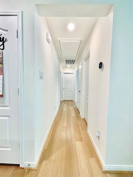 View of the hallway with beautiful laminate flooring leading to secondary bedrooms of the this spit floor plan.