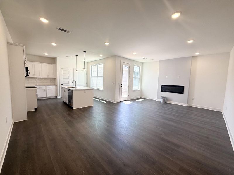 Unfurnished living room featuring dark wood-style flooring and recessed lighting