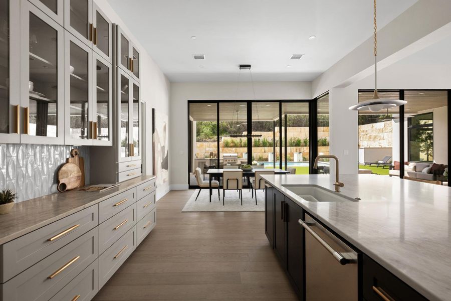 Designed for the modern epicurean, the kitchen flows seamlessly into the dining room, creating an open-concept layout that is as effortless as it is elegant
