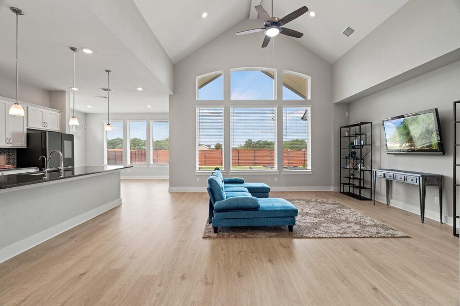 Living area featuring high vaulted ceiling, light wood-style floors, recessed lighting, and ceiling fan Living area featuring high vaulted ceiling, light wood-style floors, recessed lighting, and ceiling fan