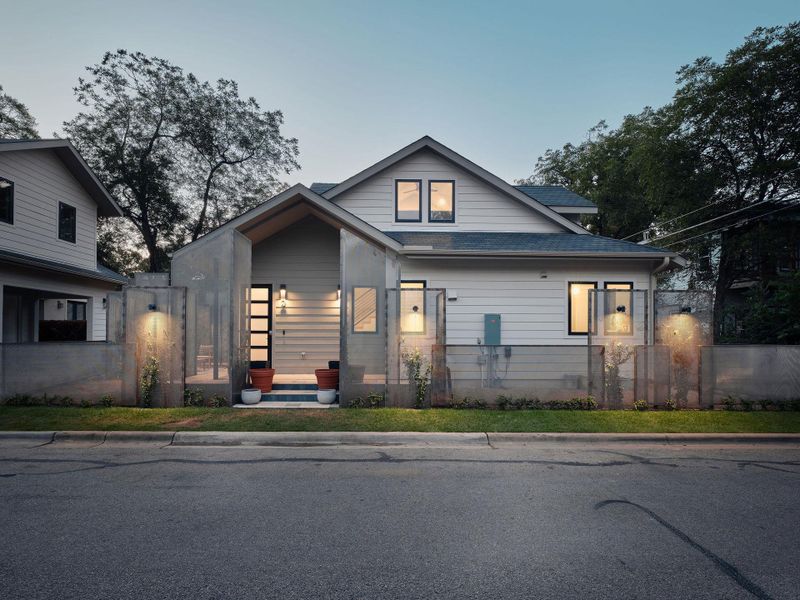 View of front of home featuring a fenced front yard and a shingled roof