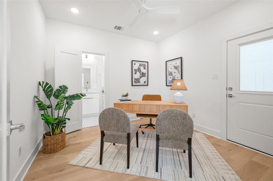 Versatile first-floor suite currently styled as a home office, complete with a full bath, generous closet storage and direct access to the private side yard and backyard space.